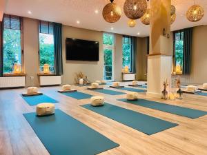 a yoga class with blue mats in a room with windows at Dümmerliebe mit Garten, 10 Min. fussläufig zum See in Hüde