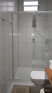 a white bathroom with a shower and a toilet at Suite 66 privativa, 11km da vila Germânica in Blumenau +8 photos