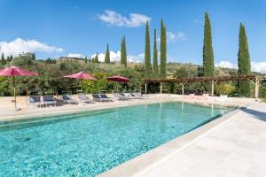 a swimming pool with chairs and umbrellas at La Fornace - Charm and modern villa in Tuscany in Campagnatico