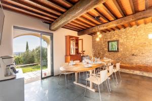 a kitchen and dining room with a wooden table and chairs at La Fornace - Charm and modern villa in Tuscany in Campagnatico
