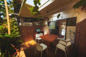 an outdoor patio with a wooden table and chairs at Kaz Nomia - à 50m de la plage Roches Noires in Saint-Gilles les Bains +5 photos