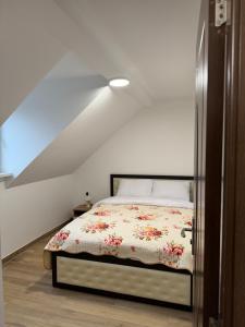 Un dormitorio con una cama con un edredón floral. en La Tranquillité Citadine, en Schiltigheim
