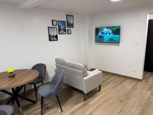 a living room with a table and a chair at La Tranquillité Citadine in Schiltigheim