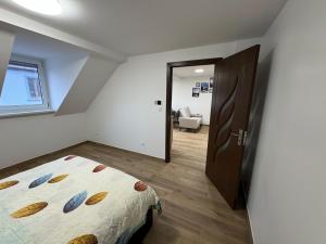 Un dormitorio con una cama y una puerta a una habitación. en La Tranquillité Citadine, en Schiltigheim