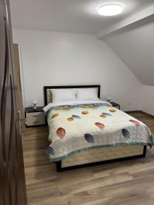 a bedroom with a bed with a comforter on it at La Tranquillité Citadine in Schiltigheim