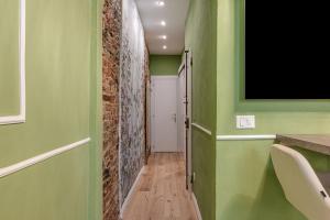 a hallway with green walls and a television on the wall at Passera Royal Suite in Florence
