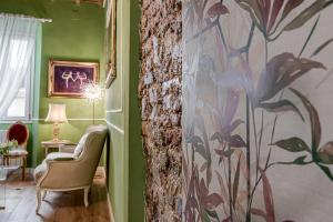 a living room with green walls and a chair at Passera Royal Suite in Florence +46 photos