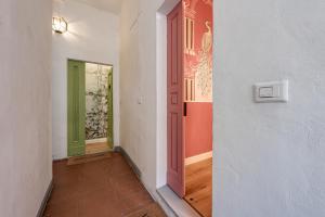 a hallway with a green door and a white wall at Passera Royal Suite in Florence