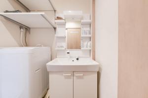 een witte badkamer met een wastafel en een koelkast bij Terrace Tokyo Otsuka in Tokyo +172 foto's