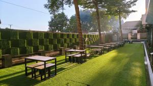 una fila de mesas y bancos en el césped en Yasmin Hotel Karawaci, en Tangerang 21 fotos más