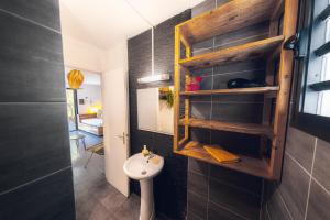 a bathroom with a sink and a toilet in a room at Kaz Nomia - à 50m de la plage Roches Noires in Saint-Gilles les Bains