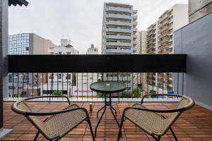 een tafel en stoelen op een balkon met uitzicht op een stad bij Terrace Tokyo Otsuka in Tokyo