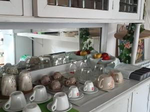 een aanrecht met een heleboel schalen en kannen bij Fiera di Roma B&B in Ponte Galeria