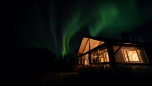 a house with the aurora in the sky at Lakeside Hideaway in Rovaniemi