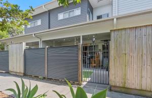 een huis met een houten hek ervoor bij Laid-Back Wurtulla Escape with Style & Charm in Kawana Waters