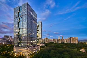 a tall glass building with a city in the background at Doubletree By Hilton Shenzhen Bay in Shenzhen
