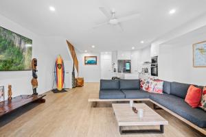 een woonkamer met een blauwe bank en een tafel bij Laid-Back Wurtulla Escape with Style & Charm in Kawana Waters