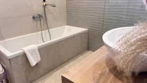 a bathroom with a bath tub and a sink at EtyekZen in Etyek