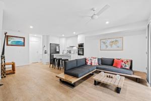 een woonkamer met een bank en een tafel bij Laid-Back Wurtulla Escape with Style & Charm in Kawana Waters