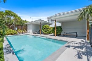 een zwembad voor een huis bij Laid-Back Wurtulla Escape with Style & Charm in Kawana Waters
