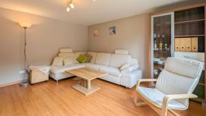 KamminkeにあるKamminke - Reetdachhausの白いソファとテーブルのあるリビングルーム