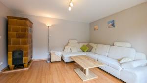 KamminkeにあるKamminke - Reetdachhausの白いソファとテーブルのあるリビングルーム