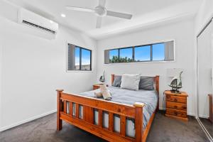 een slaapkamer met een bed en twee ramen bij Laid-Back Wurtulla Escape with Style & Charm in Kawana Waters +21 foto's
