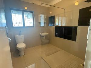 a bathroom with a toilet and a sink at Mitchell Guest House Golf Road in Pietermaritzburg