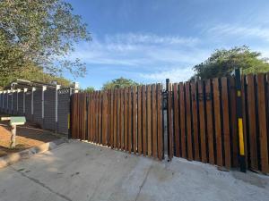 a wooden gate in front of a fence at Mitchell Guest House Golf Road in Pietermaritzburg