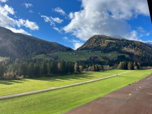 an airplane flying over a green field and mountains at Wolter Landhaus in Vipiteno