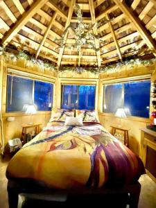 Un dormitorio con una cama grande en una habitación con ventanas. en Fabulous Tiny House Surrounded by Forest in Norwich, Connecticut, en Bargytown