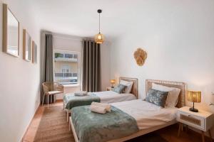 a bedroom with two beds and a window at T2 Santa Luzia E in Santa Luzia +14 photos