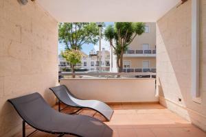 two chairs on a balcony with a view of a building at T2 Santa Luzia E in Santa Luzia
