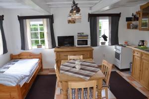 a kitchen with a table and a bed in a room at Penzion U kozy in Chřibská