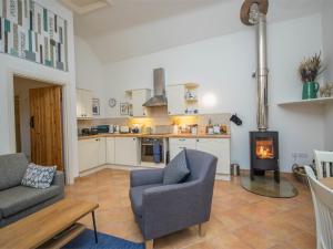 a living room with a couch and a kitchen with a stove at 1 Bed in Netherbury DC021 in Netherbury