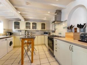 eine Küche mit weißen Schränken und einem Tisch darin in der Unterkunft 8 Bed in Hunstanton 89469 in Hunstanton