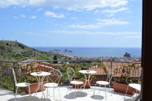 卡塔尼亞的住宿－Pupi Catania Etna B&B - #viaggiosiciliano，阳台配有桌椅,享有海景。