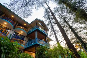 a large building with blue balconies and trees at goSTOPS Kasol in Kasol