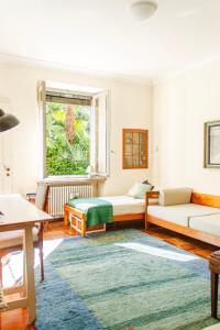 - un salon avec deux lits et une fenêtre dans l'établissement Villa dei Muralti, à Muralto