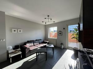 una sala de estar con un sofá y una mesa en Modern 2BR Apartment with Balcony and Stunning Views, en Reikiavik