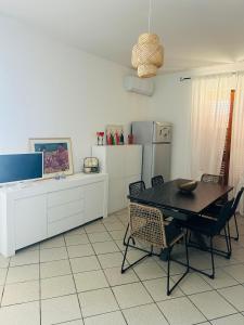 eine Küche mit Tisch und Stühlen und einem Kühlschrank in der Unterkunft Terrazza SoleLuna in Marina di Modica + 63 Fotos