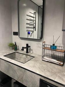 een badkamer met een wastafel en een grote spiegel bij Central Guesthouse in Kapan