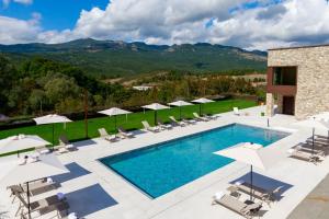a pool with chairs and umbrellas next to a building at Borgotufi Albergo Diffuso in Castel del Giudice