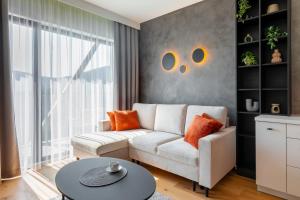 ein Wohnzimmer mit einer weißen Couch und einem Tisch in der Unterkunft Wonder Home - Orlik Residence - Apartamenty z widokiem na Śnieżkę, blisko wyciągów, Ski Arena i Kościółka Wang in Karpacz