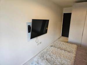 a room with a flat screen tv on a wall at Luxury 2 double bedroom Apt in the heart of Purley in Purley +17 photos