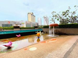 ein Brunnen mit Enten in einem Teich in einer Stadt in der Unterkunft Greenfield Regency by Antlerzone in Johor Bahru