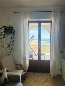 ein Wohnzimmer mit einer Glasschiebetür zu einem Balkon in der Unterkunft Terrazza SoleLuna in Marina di Modica