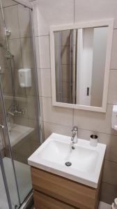 a bathroom with a white sink and a shower at GuestReady - Casa Conforto & Chiado in Ponta Delgada