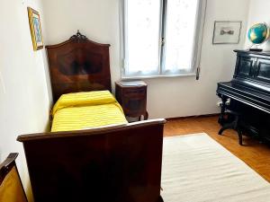 a bedroom with a bed and a piano at A casa della nonna in Imola +2 photos