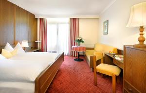 a hotel room with a bed and a desk at Hotel Hubertus in Lofer